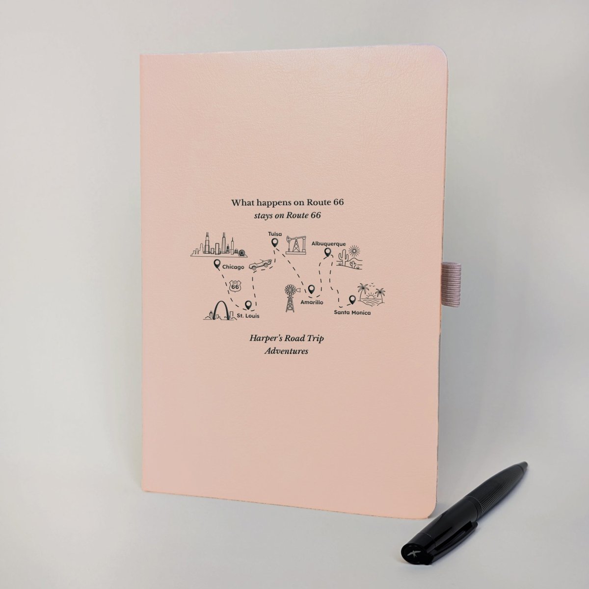 Blush pink personalised Route 66 road trip journal with black route artwork, American landmarks, convertible car and matching pen.