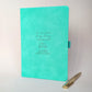 Turquoise personalised engagement journal with engraved love birds design, names Joe and Sophie, “Planning your big day” wording and coordinating gold metal pen.