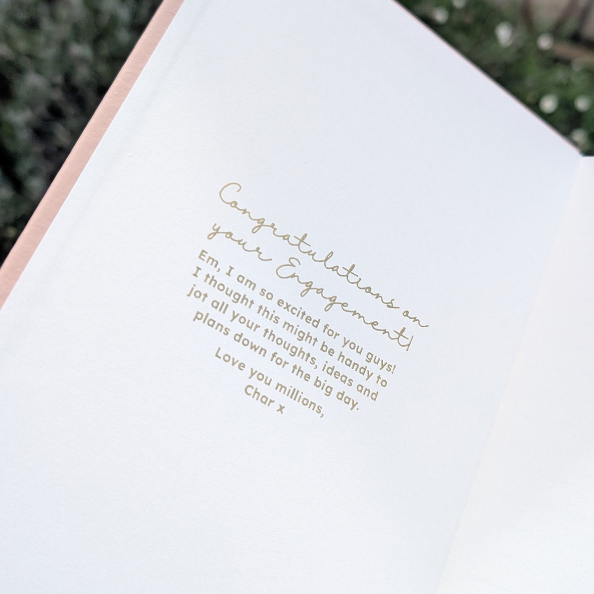 Open personalised engagement journal showing a gold inside-cover congratulations message, demonstrating the optional personal message that can be added for the newly engaged couple.