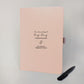 Blush personalised engagement journal with black entwined hearts design, names Ella and Hannah, “One beautiful big day, a thousand tiny details” and matching black metal pen.