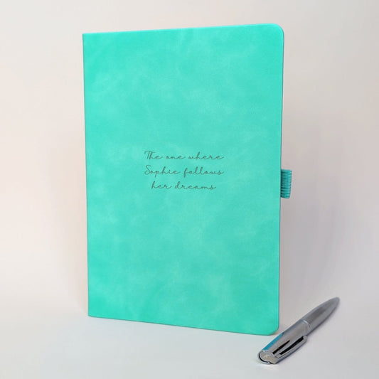 Turquoise personalised journal with matching silver pen featuring “The one where Sophie follows her dreams”, showing how the journal can be customised for a new beginning, achievement or exciting life change.