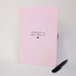 Personalised pink grief journal for a sister, with black foiled “Letters to my sister, Rebecca” wording, heart detail and matching black metal pen.