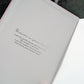 An open grief journal showing  a printed sentimental grief poem in silver script and sans serif text, photographed close up.