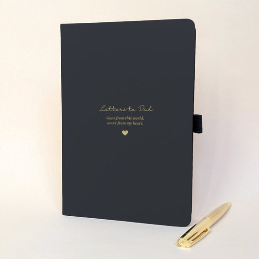 Personalised black memorial journal for Dad with gold “Letters to Dad”, “Gone from this world, never from my heart” wording, heart detail and matching gold metal pen.