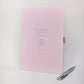 Personalised pink A5 travel journal with compass illustration and custom initials, shown with a silver metal ballpoint pen.