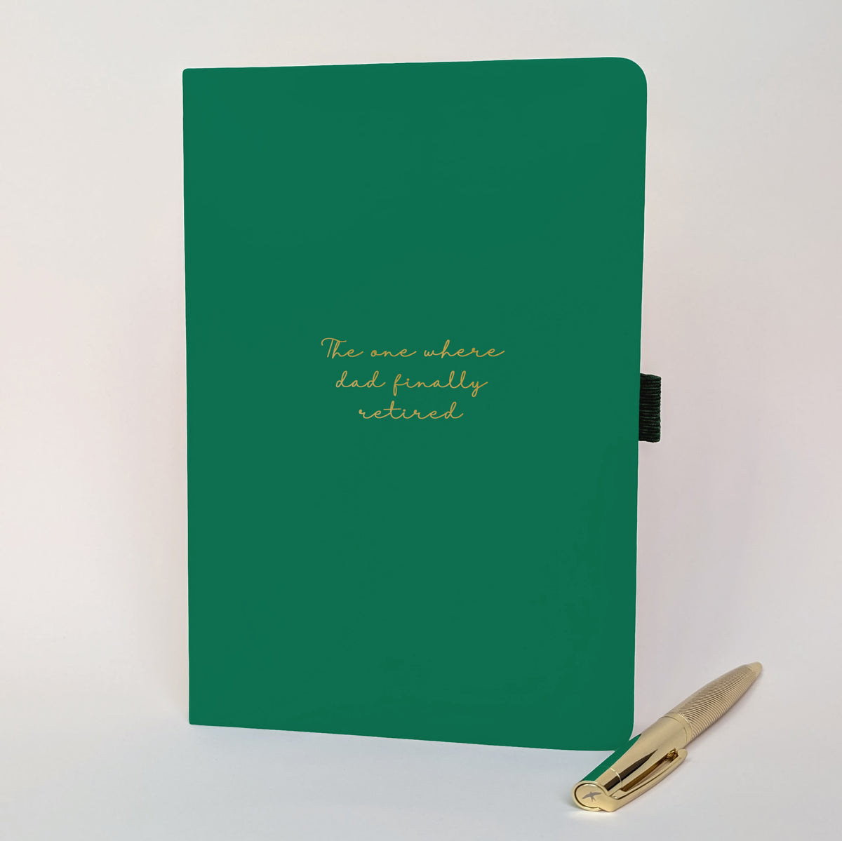 Personalised green retirement journal with gold pen and handwritten-style cover reading “The one where dad finally retired”, a fun retirement gift and keepsake notebook.
